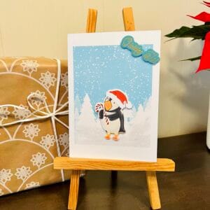 Puffin with a Christmas Candy in the Winter Forest